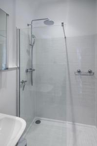 a bathroom with a glass shower with a sink at Lavender Lodge in Arundel