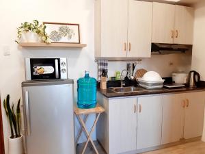 a kitchen with a refrigerator and a microwave at Mireya's Studio Condo at Goshen Towers - Session Road in Baguio