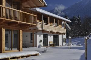 a log cabin in the winter with snow on the ground at Ferienwohnung In den Bergen in Oberammergau