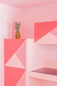 eine Ananas auf einem Regal in einem Zimmer mit rosa in der Unterkunft THULITE casa vacanze in Gaeta
