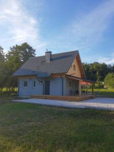 ein kleines Haus mit einer großen Veranda in der Unterkunft Domek Bobrowe Zacisze 3 in Janowice Wielkie