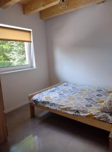 Bett in einem Zimmer mit Fenster in der Unterkunft Domek Bobrowe Zacisze 3 in Janowice Wielkie