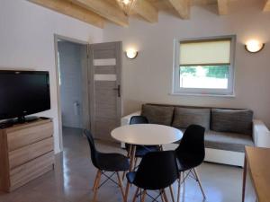 a living room with a couch and a table and chairs at Apartamenty - Domek Bobrowe Zacisze 3 in Janowice Wielkie