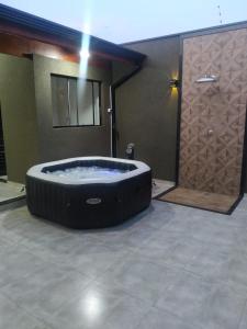 a large bath tub in a room with a door at Casa de Temporada do Spa in Olímpia +15 photos
