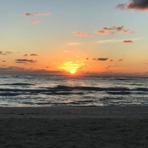 a sunset view of a beach with the sun setting at Chavez Eco Beach Camping and Cabañas in Tulum