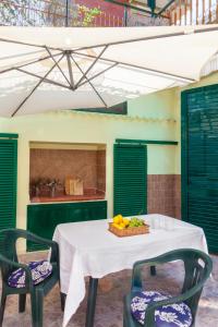einen Tisch mit Stühlen und eine Obstschale darauf in der Unterkunft THULITE casa vacanze in Gaeta