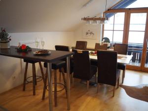 a dining room with a table and chairs with wine glasses at Ferienwohnung Grüntenpanorama im Jägerwinkl Allgäu in Rettenberg
