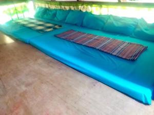 a blue couch in a room with a wooden floor at Phielle In-Home Calayo House Rental in Nasugbu