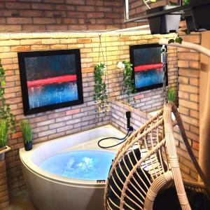 uma banheira de hidromassagem num quarto com duas janelas em Hotel Agit Congress&Spa em Lublin