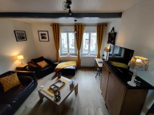 a living room with a couch and a tv at La fa'Meuse escale in Vireux-Wallerand