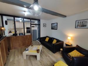 a living room with a couch and a table at La fa'Meuse escale in Vireux-Wallerand