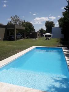 a large blue swimming pool in a yard at Cabañas Samay in Funes