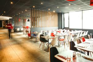 a restaurant with tables, chairs, and tables in it at ibis Portsmouth in Portsmouth