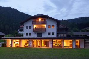 a large white house with its lights on at Masis in Rasun di Sopra