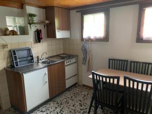 cocina con fregadero y mesa con sillas en Naturnahe Wohnung für 1 - 4 Personen, en Brienz