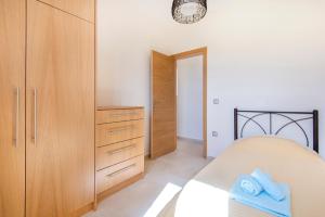 ラクハニアにあるVerona Pool Villaのベッドルーム1室(ベッド1台付)、木製キャビネットが備わります。