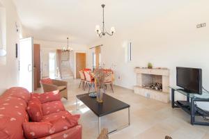 a living room with a red couch and a fireplace at Verona Pool Villa in Lachania