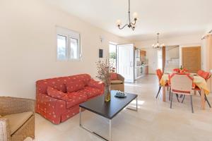 a living room with a red couch and a table at Verona Pool Villa in Lachania