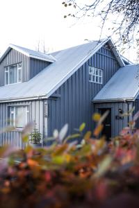 a black building with a lot of flowers in front of it at INNI - Boutique apartments in Hveragerði