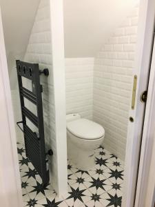 a bathroom with a toilet and a black and white tile floor at Bienvenue chez l'habitant in Provins