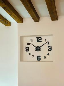 a clock on a wall on a white wall at La Moneda Home Spa in Cuenca