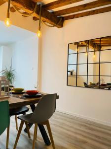 a dining room with a table and chairs and a mirror at La Moneda Home Spa in Cuenca