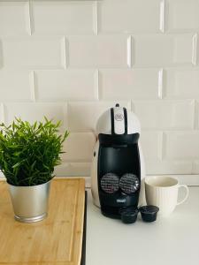 a coffee maker sitting on a counter next to a plant at La Moneda Home Spa in Cuenca
