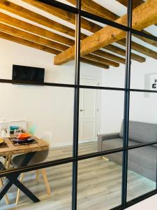 a dining room with a table and a glass wall at La Moneda Home Spa in Cuenca