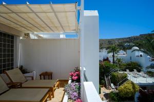 a patio with a table and chairs on a balcony at miKasa Agua Amarga & SPA in Agua Amarga