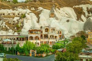 a large building in front of a mountain at Helen Cave Suites in Göreme
