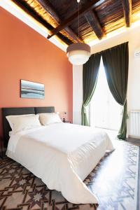 un grande letto bianco in una camera da letto con pareti arancioni di SUITE CASA FANZAGO a Napoli