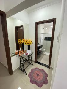 een badkamer met een tafel met bloemen en een spiegel bij Casa Moderna in Capitólio