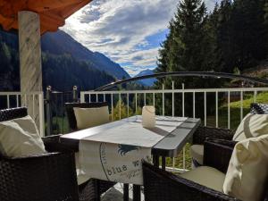 een tafel en stoelen op een balkon met uitzicht bij Apart Bella Cascata in Kappl