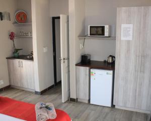 eine kleine Küche mit einem Kühlschrank und einer Mikrowelle in der Unterkunft Thuhlo lodge in Hoedspruit