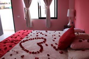 uma cama com corações com uma colcha vermelha em Hotel Boutique La Orquidea em Coatepec