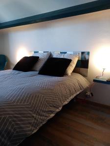 una camera da letto con un letto con due lampade sopra di Studio et chambres d'hôtes les nuits de Gesnes a Saint-Germain-du-Corbéis
