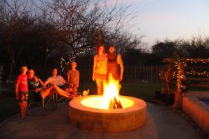 a group of people standing around a fire pit at Thuhlo lodge in Hoedspruit