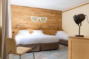 a hotel room with two beds with sunglasses on the wall at Hotel Le Dauphin in Honfleur