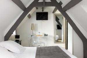 a bedroom with a white bed and a mirror at Hotel Le Dauphin in Honfleur