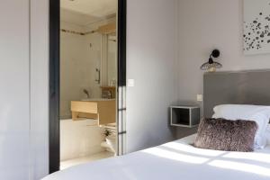 a bedroom with a bed and a bathroom with a sink at Hotel Le Dauphin in Honfleur