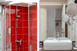 a bathroom with a sink and a shower with red tiles at Hotel Le Dauphin in Honfleur