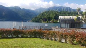 una casa su un lago con montagne sullo sfondo di Domus Alba Lenno a Lenno