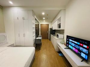 une chambre d'hôtel avec un lit et une télévision dans l'établissement Gavi Home - Luxury Apartment Vinhome Green Bay Mễ Trì Hà Nội, à Hanoï