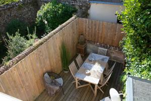 a wooden deck with a table and chairs and a fence at Hotel Le Dauphin in Honfleur