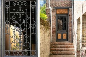 a door with a wrought iron gate next to a brick building at Hotel Le Dauphin in Honfleur