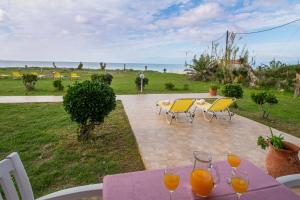a purple table with glasses of orange juice on it at Beachside Bungalows Acharavi Corfu in Acharavi