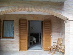 eine offene Tür eines Backsteinhauses mit einem Torbogen in der Unterkunft La Collina Del Sagrantino in Montefalco