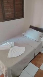 a bed with two pillows on it in a room at Pousada Boa Vista in Brotas