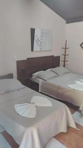 1 dormitorio con 2 camas con sábanas blancas en Pousada Boa Vista en Brotas