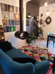 a living room with a blue couch and a table at Studio et chambres d'hôtes les nuits de Gesnes in Saint-Germain-du-Corbéis